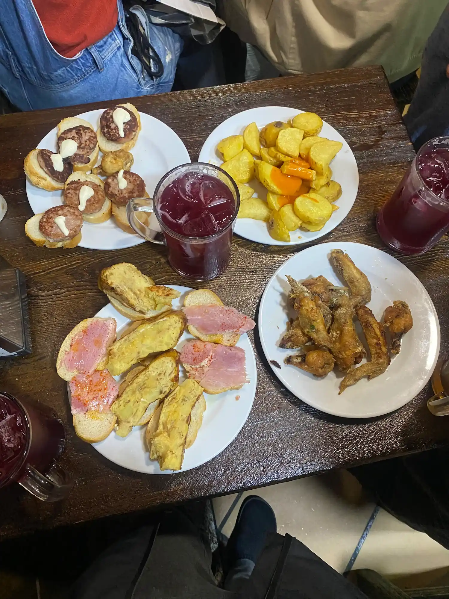 A large plate of free tapas next to a drink at El Tigre